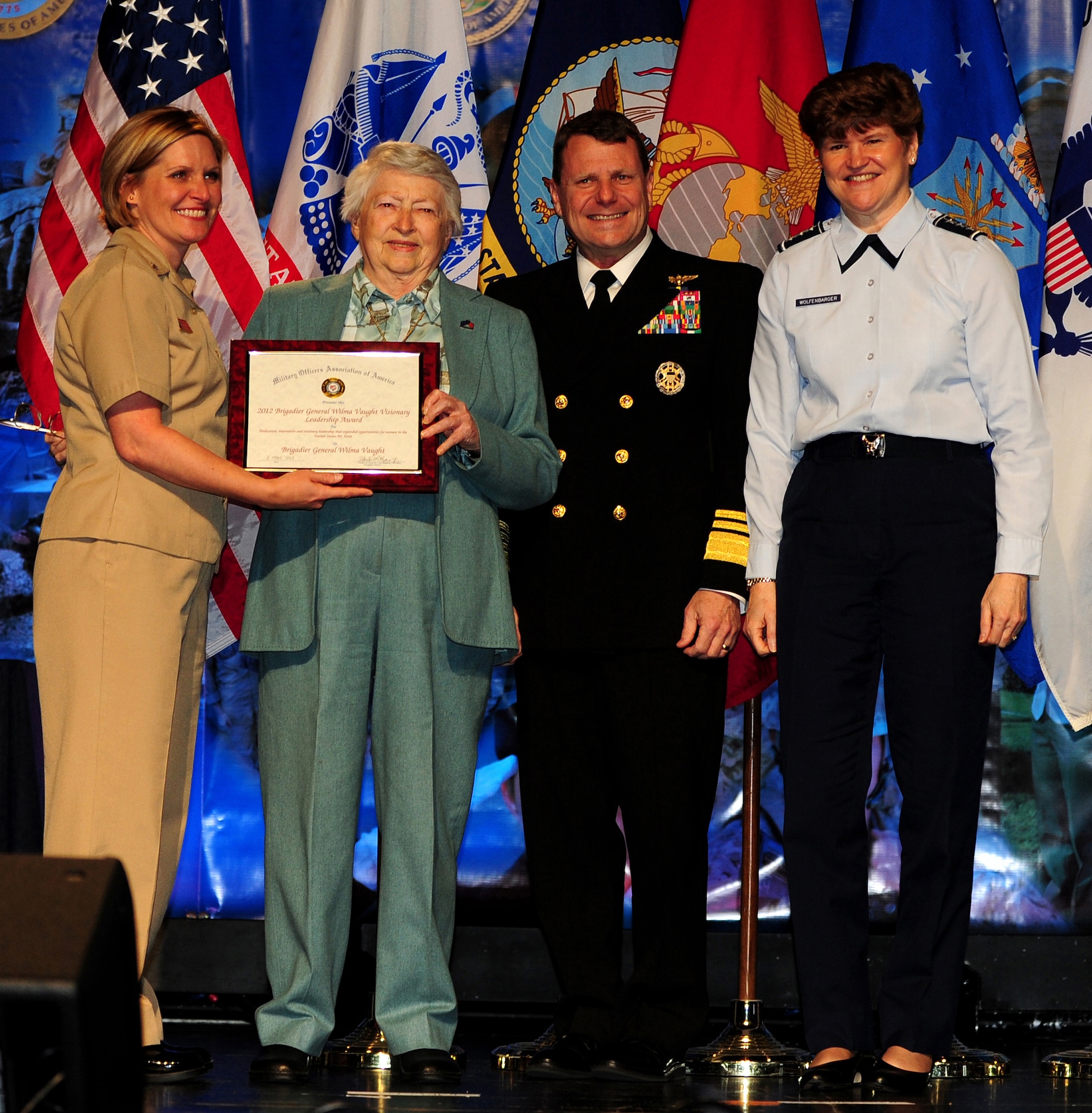 Retired Brig. Gen. Wilma Vaught receives the inaugural Brigadier General Wilma Vaught Visionary Leadership Award during the 2012 Joint Women's Leadership Symposium, March 5. The Air Force Award will be given to the officer, enlisted, and civilian for demonstrated visionary leadership that expanded opportunities for women and used innovation to inspire others to see the Air Force as a positive place for women to share their talents. Presenting Vaught the award are, Cmdr. Nicole Shue; Vice Adm. William Gortney; and Lt. Gen. Janet Wolfenbarger. (U.S. Air Force Photo Senior Airman Christina Brownlow)