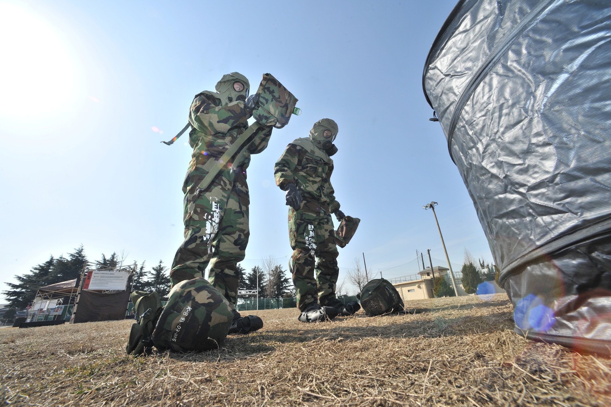 After using the M295 decontamination packet, Republic of Korea Air Force and Army personnel remove their gas mask carrier and Kevlar helmet during counter chemical, biological, radiological, nuclear and explosive training led by 8th Civil Engineer Squadron readiness and emergency management flight at Kunsan Air Base, ROK, Feb. 29, 2012. The training involved joint post attack chemical, biological and radiological reconnaissance operations to determine the extent of CBRN hazards to the installation. (U.S. Air Force photo by Senior Airman Brittany Y. Auld/Released)