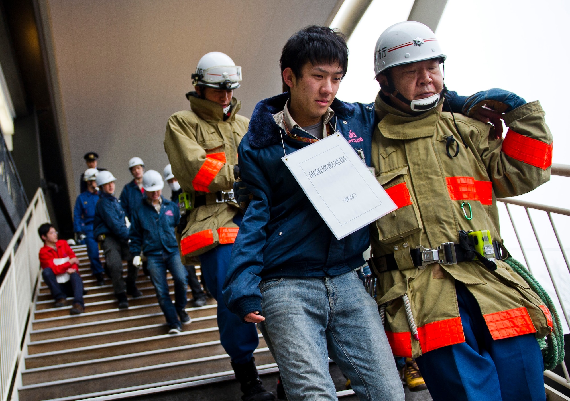 YOKOTA AIR BASE, Japan -- Firefighters with the Tokyo Fire Department assist simulated victims during the Fussa Fire Department Rescue Response Exercise outside a Japanese department store March 2, 2012. More than 130 firefighters participated in the exercise. (U.S. Air Force photo/Staff Sgt. Chad C. Strohmeyer)