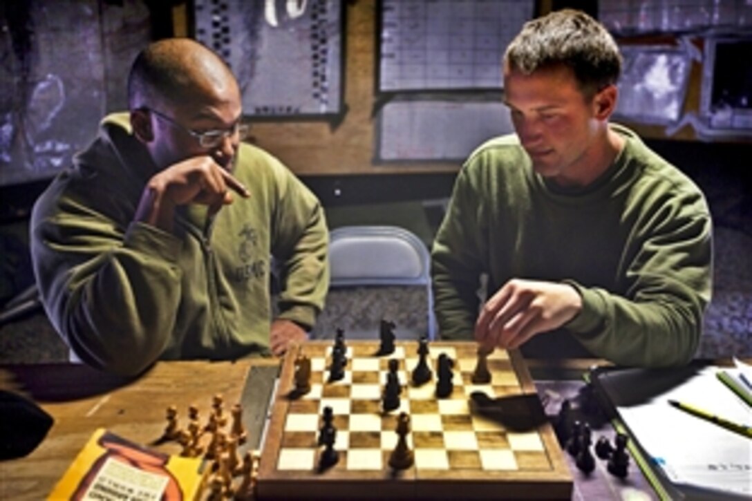 U.S. Marine Sgt. Jeremy Scott, left, and Lance Cpl. Tyler Dickinson play chess after work on Patrol Base Bury in the Garmsir district in Afghanistan's Helmand province, Feb. 26, 2012. Scott, a squad leader, and Dickinson, an assaultman, are assigned to Kilo Company, 3rd Battaltion, 3rd Marine Regiment.
