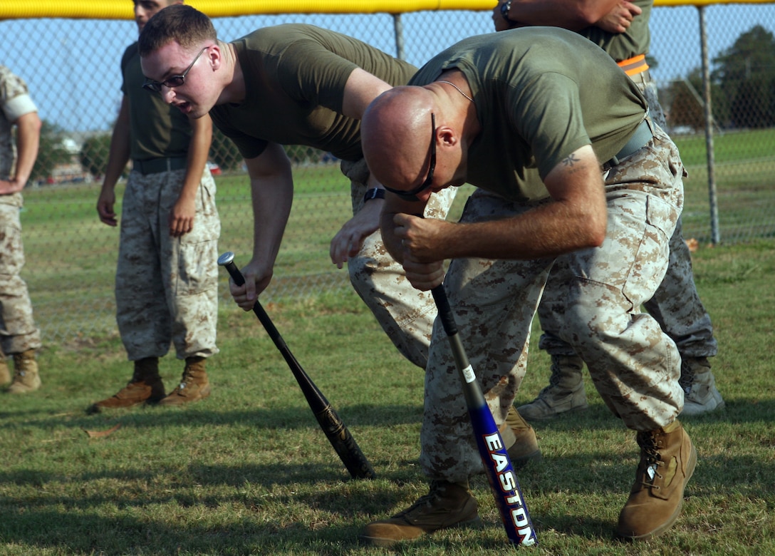 Two Marines in Headquarters Battalion, 2nd Marine Division, spin around baseball bats for a Dizzy Izzy race during the Headquarters Battalion field meet aboard Marine Corps Base Camp Lejeune, N.C., July 29, 2011. The field meet was the closing to a year-long competition between the companies within the battalion