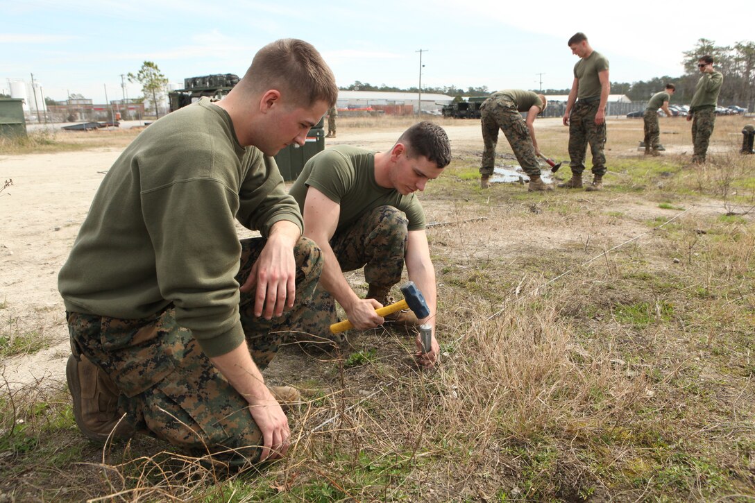 Lance Cpls. Jacob T. Cannon (left) and David C. Sterling, two technical controller Marines with Communications Company, Combat Logistics Regiment 27, 2nd Marine Logistics Group, install grounding cables during a training exercise aboard Camp Lejeune, N.C., Feb. 29, 2012. During the exercise the participating Marines tested their capabilities in a simulated field environment in accordance with their training and readiness standards.  