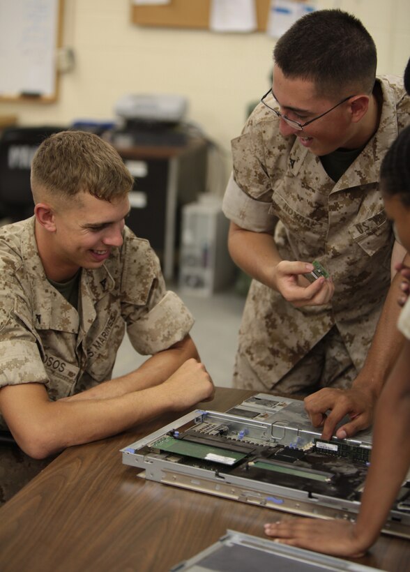 Lance Cpl. Kevin D. Drosos, a data network specialist with Cyber Platoon, Communications Company, Headquarters Battalion, 2nd Marine Division, looks on as fellow data network specialist Lance Cpl. Andres E. Roybal pulls parts from a server aboard Marine Corps Base Camp Lejeune, N.C., July 27, 2011. Roybal says Drosos’ enthusiastic personality makes his job much easier.