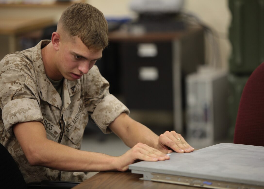 Lance Cpl. Kevin D. Drosos, a data network specialist with Cyber Platoon, Communications Company, Headquarters Battalion, 2nd Marine Division, pulls on a server in an attempt to open it aboard Marine Corps Base Camp Lejeune, N.C., July 27, 2011. Drosos is currently learning how to manage a server system.