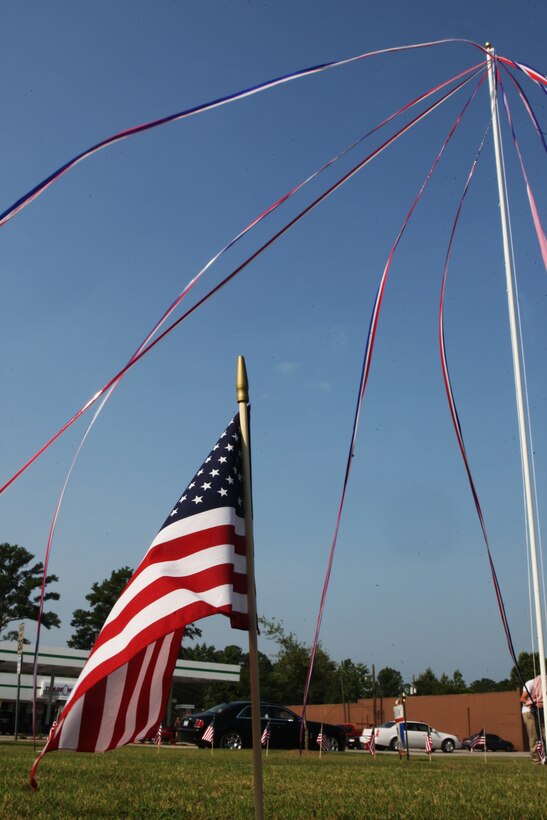 An American flag, one of 50 representing each state of the union, sits at one edge of the raised red, white and blue streamers which represent the height of the Freedom Jet, the center fountain of water in the slated Freedom Fountain memorial project during the fountain’s groundbreaking ceremony at the corner of Johnson Boulevard and New Bridge Street, July 28. The fountain, to be rebuilt in the spirit of the first fountain, removed due to construction, will honor all service men and women who have passed through the Onslow County area in support of the country.