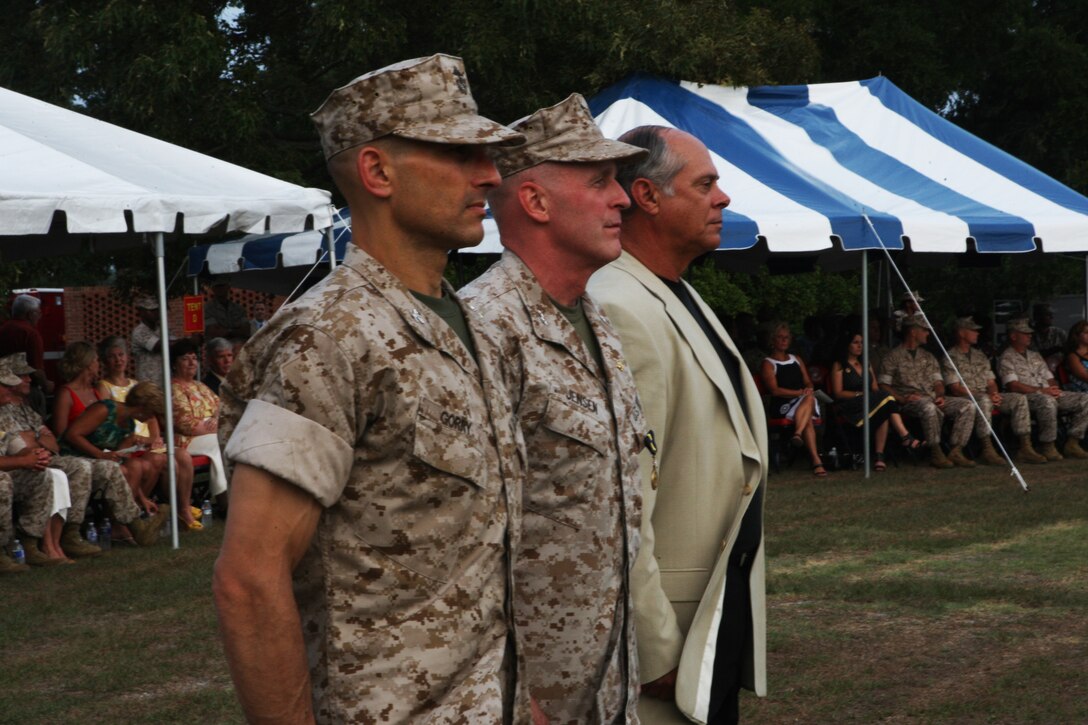 (From left to right) Col. Thomas A. Gorry, brigadier general select, incoming commander of Marine Corps Installations East; Maj. Gen. Carl B. Jensen, outgoing commanding general of MCIEAST and retired Maj. Gen. Robert C. Dickerson, first CG of MCIEAST, stand during a pass and review of troops following the MCIEAST change of command ceremony and Jensen’s retirement at the 2nd Marine Logistics Group Amphitheater, July 22.