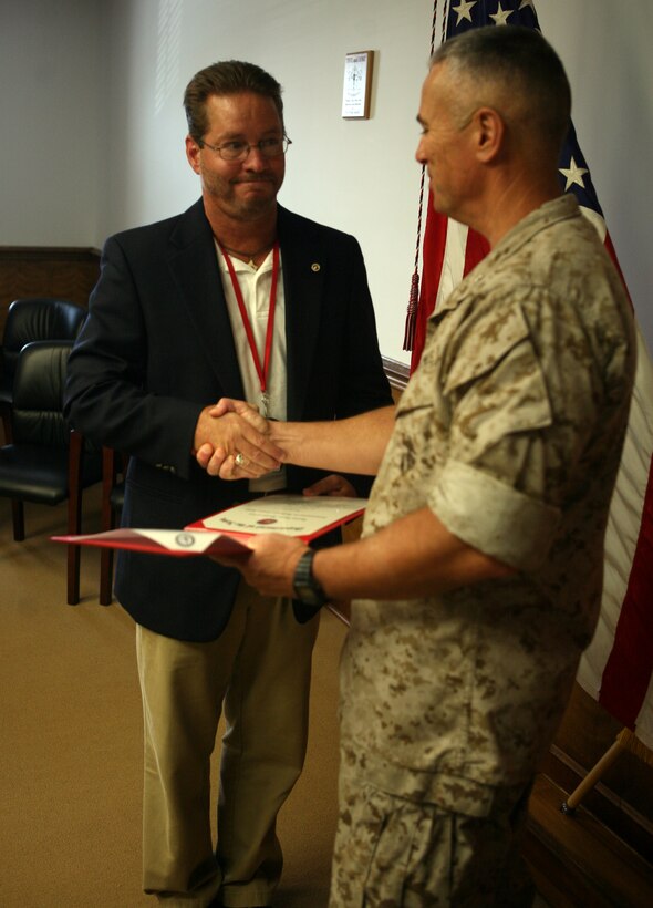 Ronald Salyer, the II Marine Expeditionary Force operations officer, is awarded the certificate for the Navy Meritorious Civilian Service Medal, July 21, 2011, aboard Marine Corps Base Camp Lejeune, N.C. For almost a decade, Salyer has worked with the II MEF Communications Security Office, which works to protect our nation’s secrets from our adversaries.