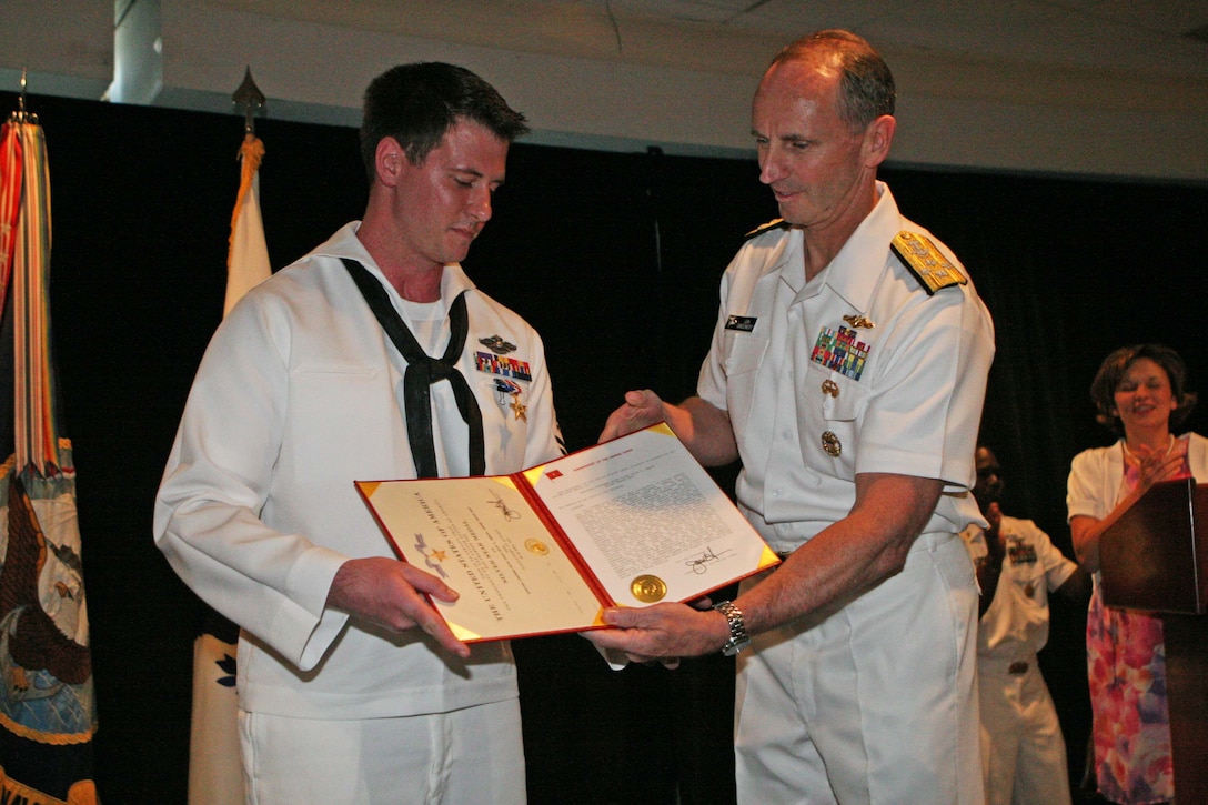 Petty Officer 2nd Class Jacob Emmott, a corpsman with 1st Battalion, 2nd Marine Regiment, 2nd Marine Division, is presented his Silver Star award citation by Adm. Jonathan W. Greenert, the vice chief of naval operations at the Third Annual Naval Safe Harbor Award Ceremony in Washington D.C., July 14, 2011. Emmott was awarded the Silver Star, the third highest award for valor in the United States armed forces, for his actions in Helmand Province, Afghanistan, 2010.