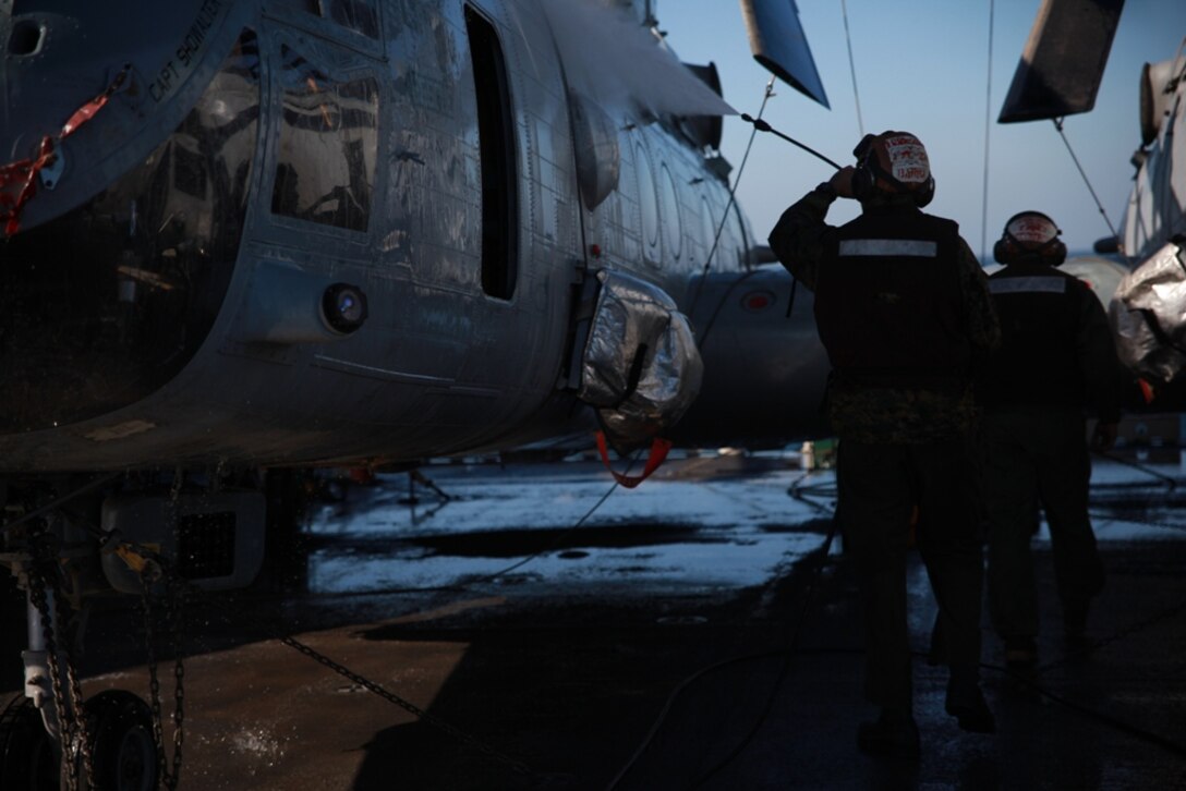 Marines serving with Marine Medium Helicopter Squadron 268 (Reinforced), the aviation combat element for the 11th Marine Expeditionary Unit, wash a CH-46E Sea Knight aboard USS Makin Island here March 6. The unit is deployed as part of the Makin Island Amphibious Ready Group, a U.S. Central Command theater reserve force. The group is providing support for maritime security operations and theater security cooperation efforts in the U.S. Navy's 5th Fleet area of responsibility.