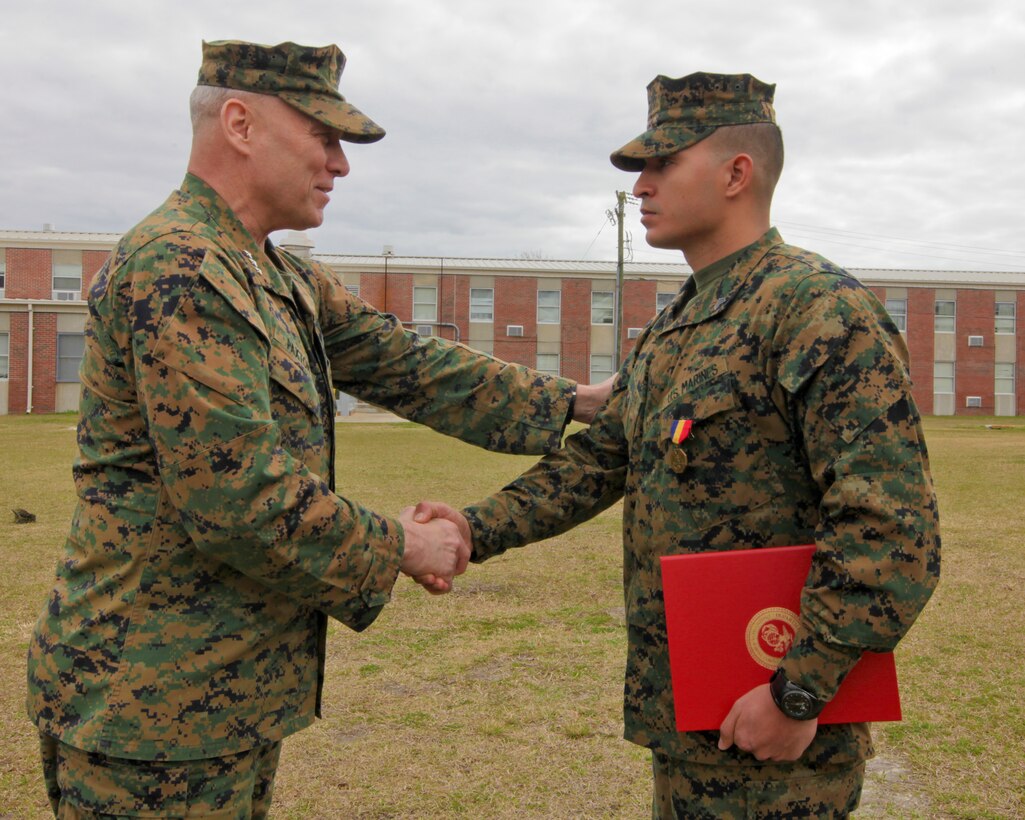 Lt. Gen. John M. Paxton, II Marine Expeditionary Force commanding general, shakes hands with Sgt. Diego R. Zuluaga, a radio operator with Special Purpose Marine Air-Ground Task Force 12.2, after presenting him with a Navy-Marine Corps Medal aboard Camp Lejeune, N.C., March 7, 2012.  Zuluaga was driving to his reserve drill company in Amityville, N.Y., when he and another Marine saw a car crash survivor trapped in a burning vehicle.  At great personal risk, Zuluaga rushed to the vehicle and pulled the man from the burning wreckage.