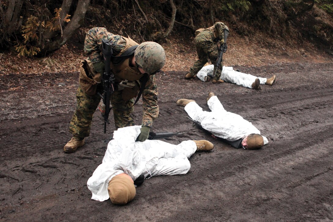 Marines with Combat Logistics Regiment 35 search the bodies of mock enemy combatants at the Combined Arms Training Center, Camp Fuji, Japan, March 8. CLR-35 is part of 3rd Marine Logistics Group, III Marine Expeditionary Force.