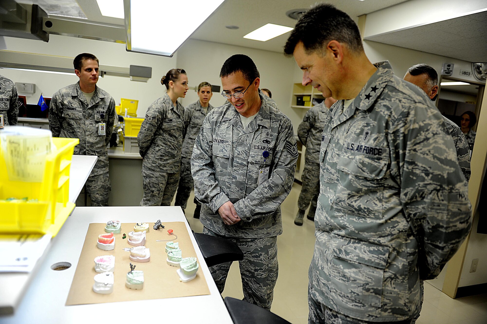 U.S Air Force Tech. Sgt. Steve Lovato, 18th Dental Squadron dental laboratory craftsman, shows some of the things that can be created at the 18th DS lab with U.S. Air Force Maj. Gen. Gerard Caron, 79th Medical Wing, Andrews Air Force Base, Md., assistant surgeon general for dental services, at Kadena Air Base, March 7, 2012. Caron had an all call with the 18th DS Airmen earlier in the day to answer questions about recent changes and then partook in a dental clinic tour. (U.S. Air Force photo by Airman 1st Class Brooke P. Beers/Released)