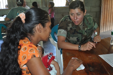LA CEIBA, Honduras - Logistics Specialist 2nd Class Petty Officer Claudia Salas, a member of Army Forces Battalion, Soto Cano Air Base, Honduras, talks to a patient during the medical readiness and training exercise here March 7. Salas served as a translator for Capt. Eric Baroni, a Medical Element physician’s assistant, during the MEDRETE. The team saw more than 300 people on the first day of the readiness exercise. This exercise serves as a professional exchange between U.S. and Honduran doctors and nurses which will allow for improved patient treatment and enhance the U.S., Honduran partnership. (U.S. Air Force photos/Capt. Candice Allen)