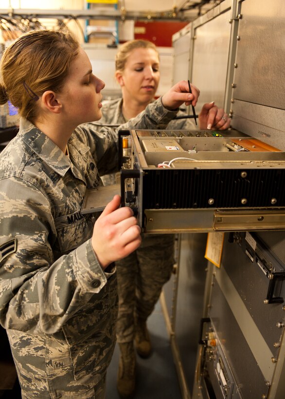 Airmen 1st Class Cassandra Mallory (left) and Taylor Anliker, 28th Communications Squadron airfield systems technicians, change a circuit card in a radio transmitter at Ellsworth Air Force Base, S.D., March 6, 2012. The circuit card allows the radio to be tuned and calibrated to produce the proper secure frequency. (U.S. Air Force photo by Airman Alystria Maurer/Released)
