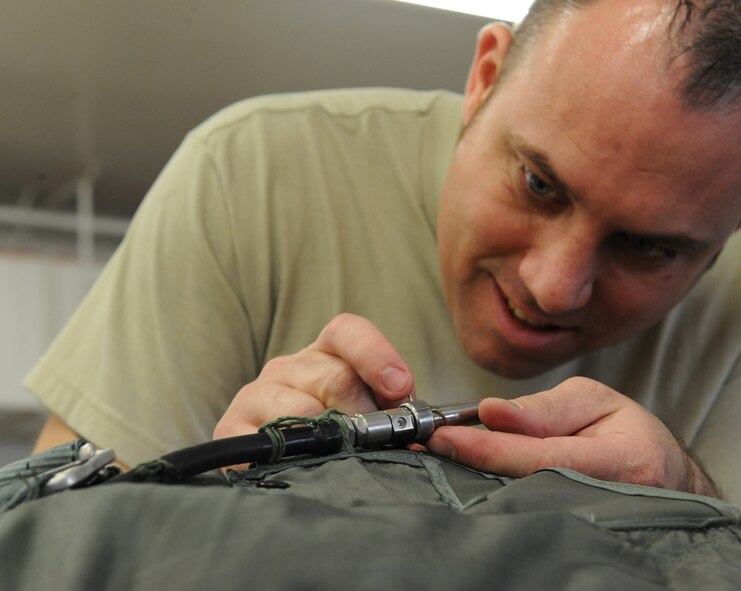 Tech. Sgt. Marcus Kelley, 2nd Operation Support Squadron aircrew flight equipment, removes parts from an older parachute on Barksdale Air Force Base, La., March 6. Once a parachute harness reaches its expiration date, a harnesses rebuild must be conducted. (U.S. Air Force photo/Airman 1st Class Micaiah Anthony)(RELEASED)