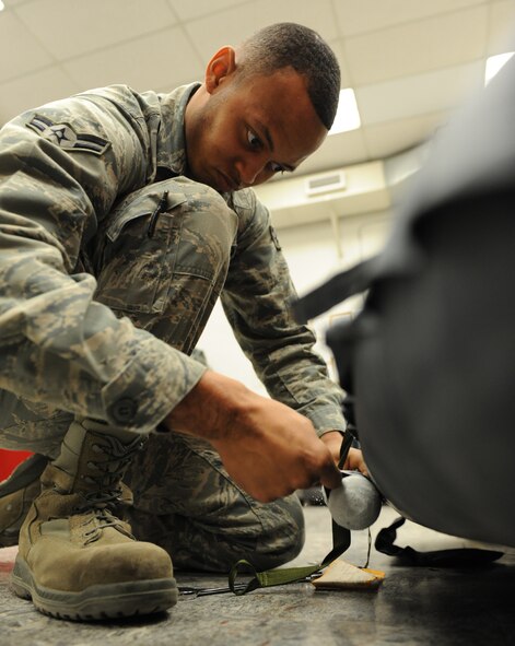 Airman 1st Class Jereme Haynie, 2nd Operation Support Squadron aircrew flight equipment, removes a carbon dioxide tank from a life raft on Barksdale Air Force Base, La., March 6. The carbon dioxide tank is used to help inflate the life raft. In the event the life raft doesn't inflate, aircrew members can utilize the rafts manual inflation tubes. (U.S. Air Force photo/Airman 1st Class Micaiah Anthony)(RELEASED)
