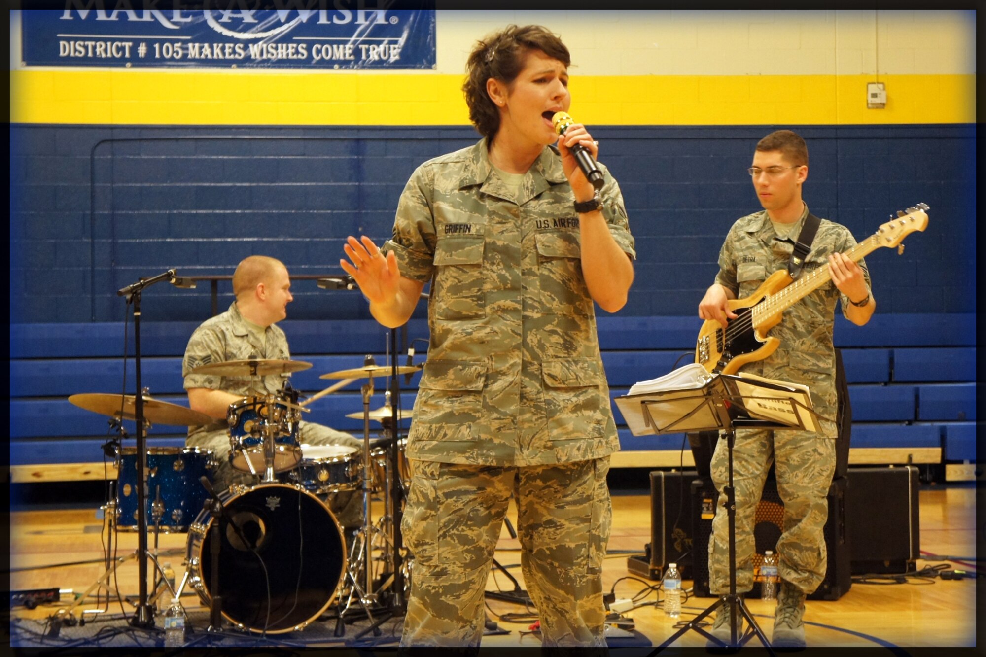 Off to a great start, the newest members of the Air Force Band of Mid-America - vocalist A1C Joann Griffin and bassist A1C Andy Detra - premier with SSgt Jody Walker and the rock-band "Starlifter" during a community outreach performance at Pontiac Jr High on Feb. 29, 2012. Recently arrived from basic training, the two A1C's provide a positive example of the success that students of Pontiac Jr High can achieve by joining the Air Force.   (Photo courtesy/Michelle White)