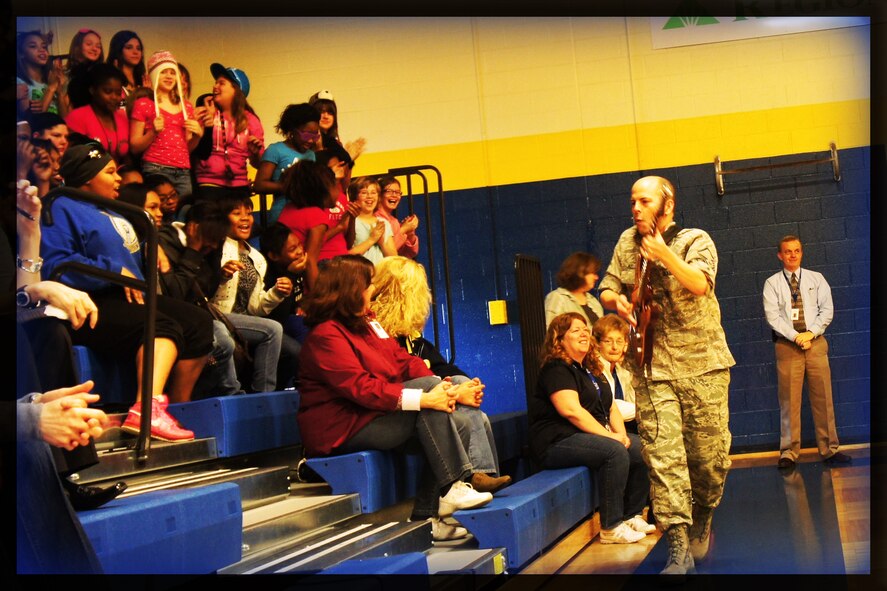 MSgt Jerry Kelley, NCOIC and guitarist with the Air Force Band of Mid-America rock-band "Starlifter," performs up close and personal with students and faculty during a concert at Pontiac Jr High on Feb. 29, 2012. In addition to broadening public understanding of the Air Force mission and opportunities, the "Starlifter" performance kicked off "Music in Our Schools" month and encouraged building character through music.  (Photo courtesy/Michelle White)