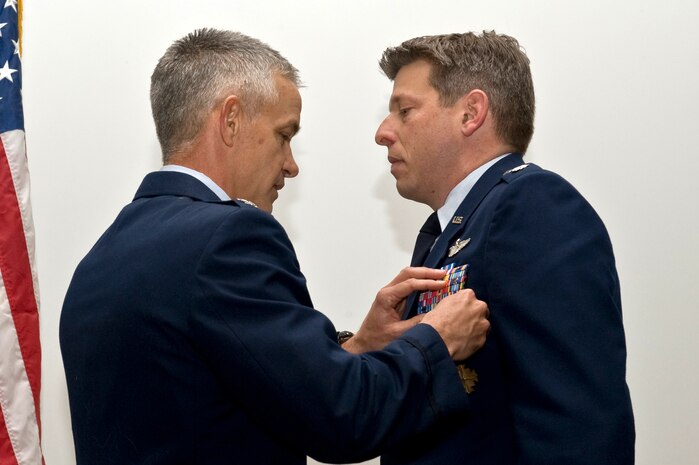 U.S. Air Force Col. Tod Fingal, 414th Combat Training Squadron commander, presents the Distinguished Flying Cross decoration to Lt. Col. Daren Sorenson, 414 CTS director of staff, during a presentation ceremony, March 2, 2012 at Nellis Air Force Base, Nev. Sorenson received the decoration for his actions while flying an F-15E Strike Eagle in eastern Afghanistan. He led a formation of aircraft, providing close air support to coalition forces ambushed in a remote mountain district. At great personal risk, Sorenson and his wingmen destroyed an enemy force and a cave complex used as their regional base of operations, saving the lives of about 50 soldiers. (U.S. Air Force photo by Airman 1st Class Daniel Hughes)