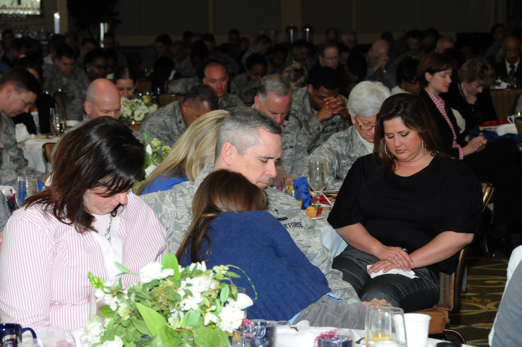 Chaplain (Maj.) Mark Thomas and his wife, Cynthia and daughter, Meredith, 10, bow their heads during a prayer, during Keesler’s National Prayer Breakfast ceremony March 6, 2012, at the Bay Breeze Event Center, Keesler Air Force Base, Miss.  The ceremony also provided demonstrations from Team Impact and the United States Air Force Honor Guard Drill Team.  (U.S. Air Force photo by Kemberly Groue)