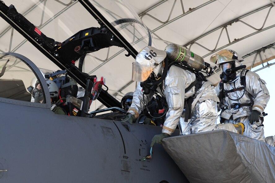 U.S. Air Force Senior Airman Mark Martinez II lifts the canopy of an F-15E Strike Eagle as Senior Airman Jorge Bracetty prepares to remove an aircrew member from the cockpit during exercise Coronet Warrior on Seymour Johnson Air Force Base, N.C., March 7, 2012.This exercise scenario simulated an aircraft fire with aircrew aboard who the fire emergency services flight were dispatched to extract. Martinez, 4th Civil Engineer Squadron fire emergency services flight firefigher, hails from Toledo, Ohio. Bracetty, 4th CES fire emergency services flight firefighter, is a native of Springfield, Mass. (U.S. Air Force photo/Airman 1st Class Mariah Tolbert/Released)