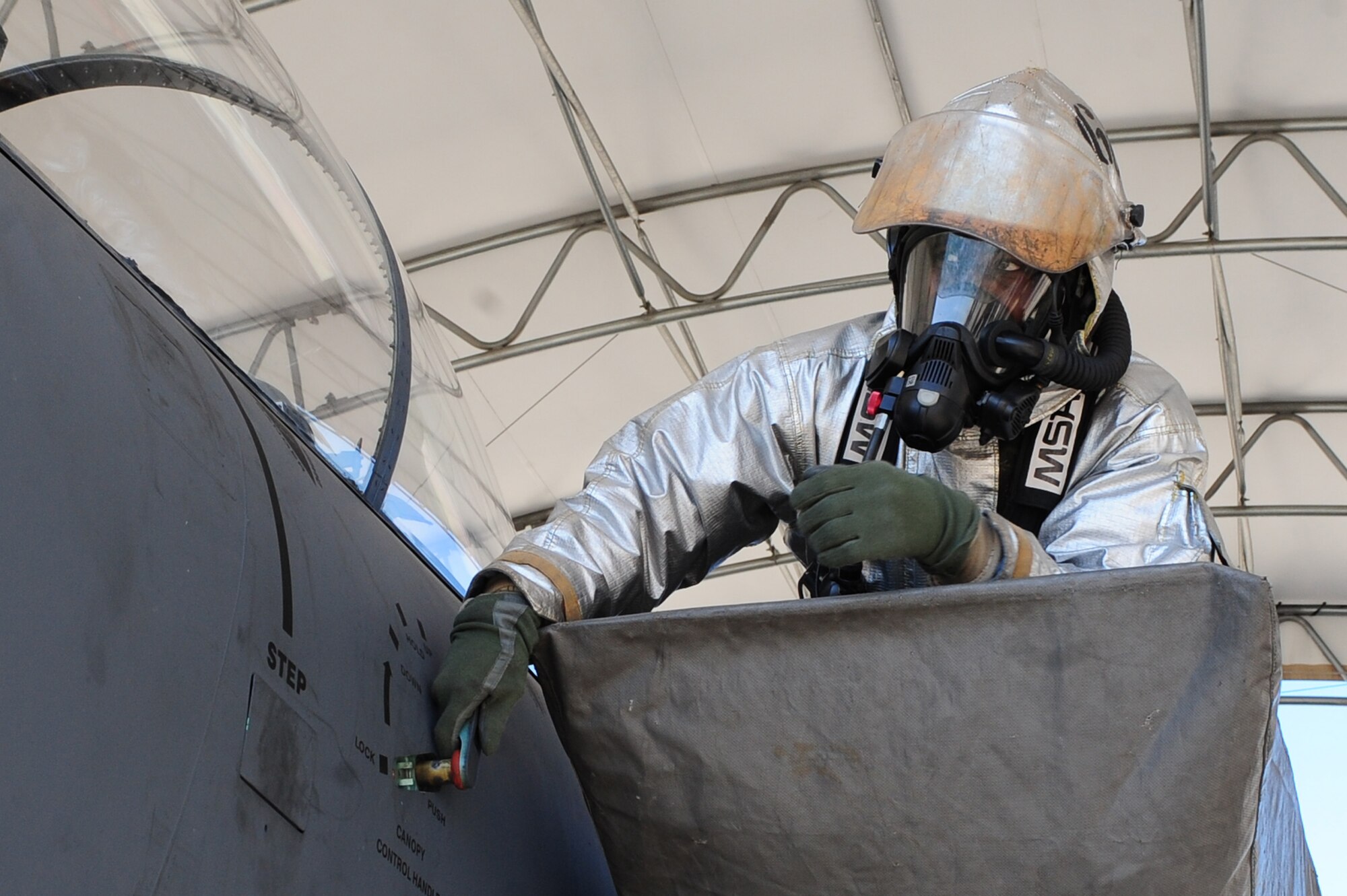 U.S. Air Force Senior Airman Mark Martinez II manually lifts the canopy of an F-15E Strike Eagle to extract the aircrew out during exercise Coronet Warrior 2012 on Seymour Johnson Air Force Base, N.C., March 7, 2012. He had to manually lift the canopy because the hydralic fluid was cut off during the exercise. Martinez, 4th Civil Engineer Squadron fire emergency services flight firefighter, hails from Toledo, Ohio. (U.S. Air Force photo/Airman 1st Class Mariah Tolbert/Released)