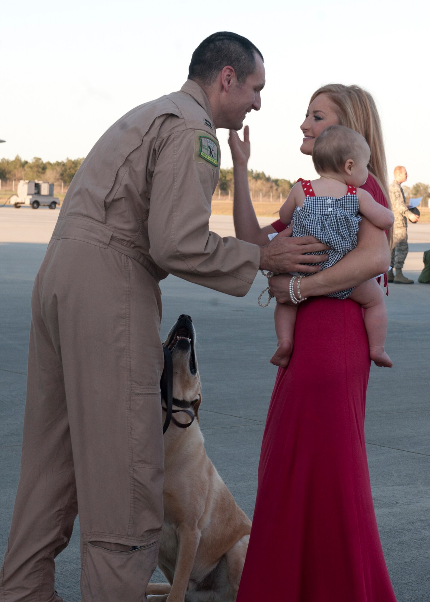 U.S. Air Force Capt. Sam McCurry, 71st Rescue Squadron,  embraces his family and their dog after returning home on an HC-130P Hercules Mar. 5, 2012, at Moody Air Force Base, Ga. The 71st RQS and other units were in Camp Bastion, Afghanistan, for four months in support of Operation Enduring Freedom. (U.S. Air Force photo by Senior Airman Eileen Meier/Released)