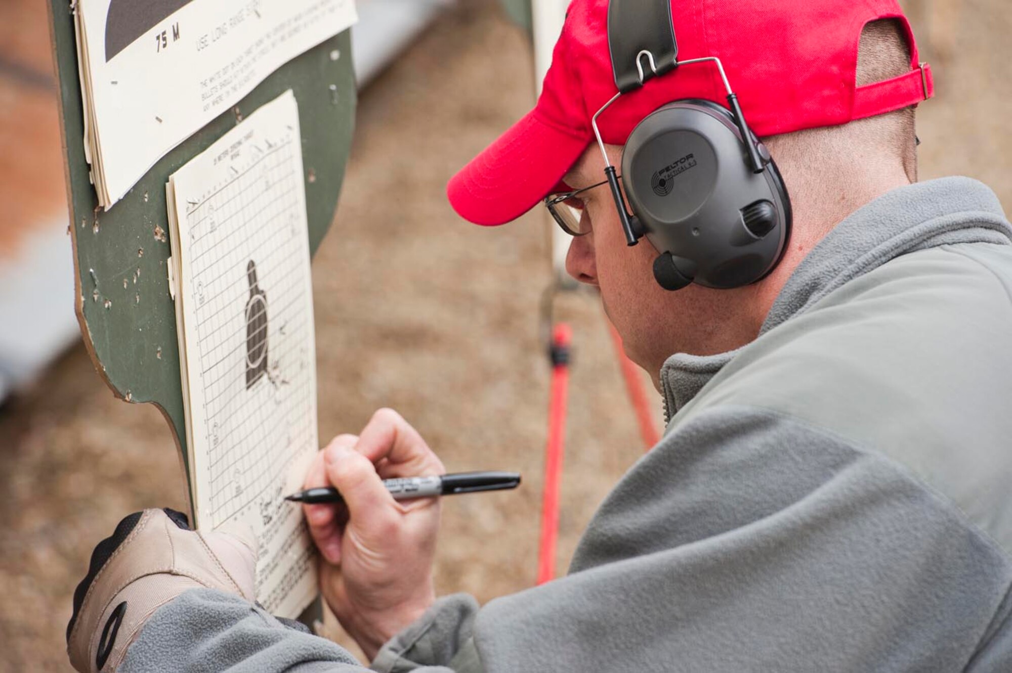Air Force Reservist Senior Airman Josh Buckenberger, a 910th Combat Arms Training and Maintenance combat arms instructor, checks the target of a 910th Civil Engineer Squadron member after a round of M4 rifle firing here, March 3, 2012. 910th Combat Arms Training and Maintenance conducts weapons courses each Unit Training Assembly in preparation for the 2013 Operational Readiness Inspection and to meet training requirements. U.S. Air Force photo by Eric M. White. 