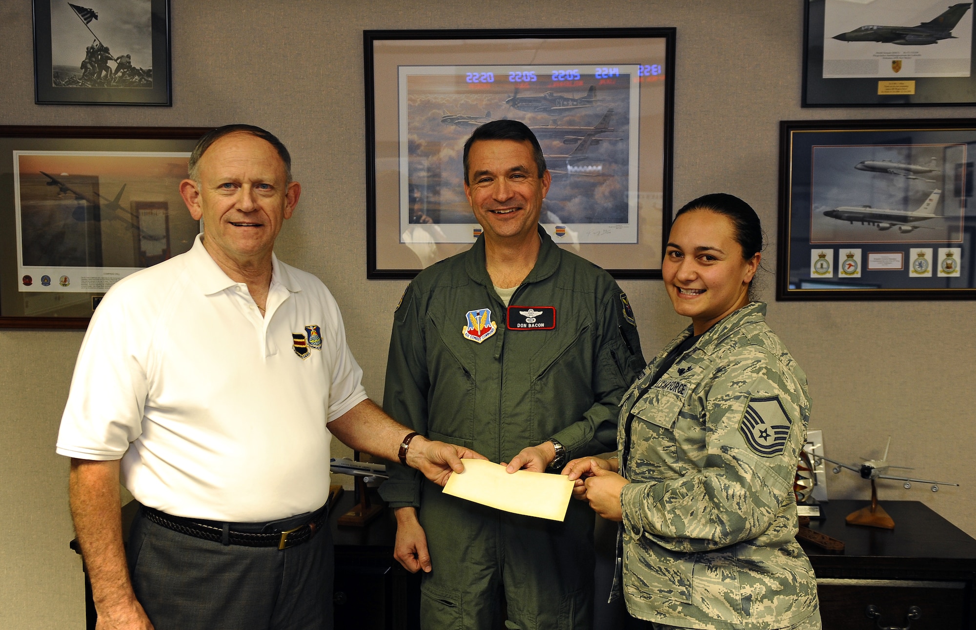 Retired Col. Jim Thomas, 55th Wing Association president, along with Air Force Brig. Gen. Donald Bacon, 55th Wing commander, present a check for $1,000 to Air Force Master Sgt. Kanani Reed, Birthday Ball Committee Chair Person, to aid junior enlisted Airman in attending the annual 55th Wing Birthday Ball event at Offutt Air Force Base, Neb., March 1.  Bacon expressed tremendous gratitude for the generous donation from the 55th Wing Association.  (U.S. Air Force photo by Josh Plueger/Released).