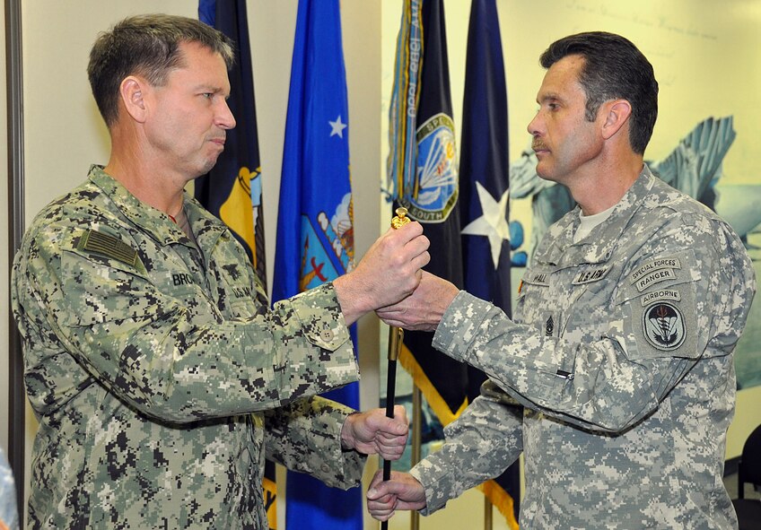 Navy Rear Adm. Thomas L Brown II, Commander of Special Operations Command South, hands Command Sgt. Maj. Thomas Wall the Non-Commissioned Officer sword Feb. 28. The sword is passed down from one SOCSOUTH Command Sgt. Maj. to the next. (U. S. Air Force Photo by Senior Airman Jacob Jimenez, 482nd Fighter Wing Public Affairs.) 