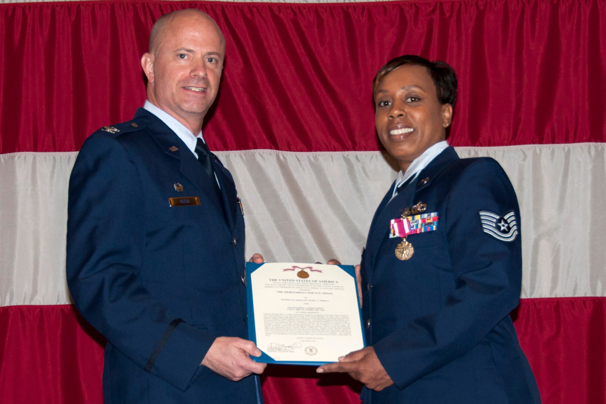 Colonel Jonathan Ellis, the commander of the 307th Bomb Wing, poses with Tech. Sgt. Mary A. Jordan, NCOIC, commander support staff, after presenting her with The Meritorious Service Medal during the 307th BW Commander’s Call at Hoban Hall on Barksdale Air Force Base, La., March 4, 2012. Sergeant Jordan was awarded the medal for meritorious service while assigned to the 93rd BS from July 1, 2009 to Feb. 1, 2010. (U.S. Air Force photo/Staff Sgt. Ted Daigle)
