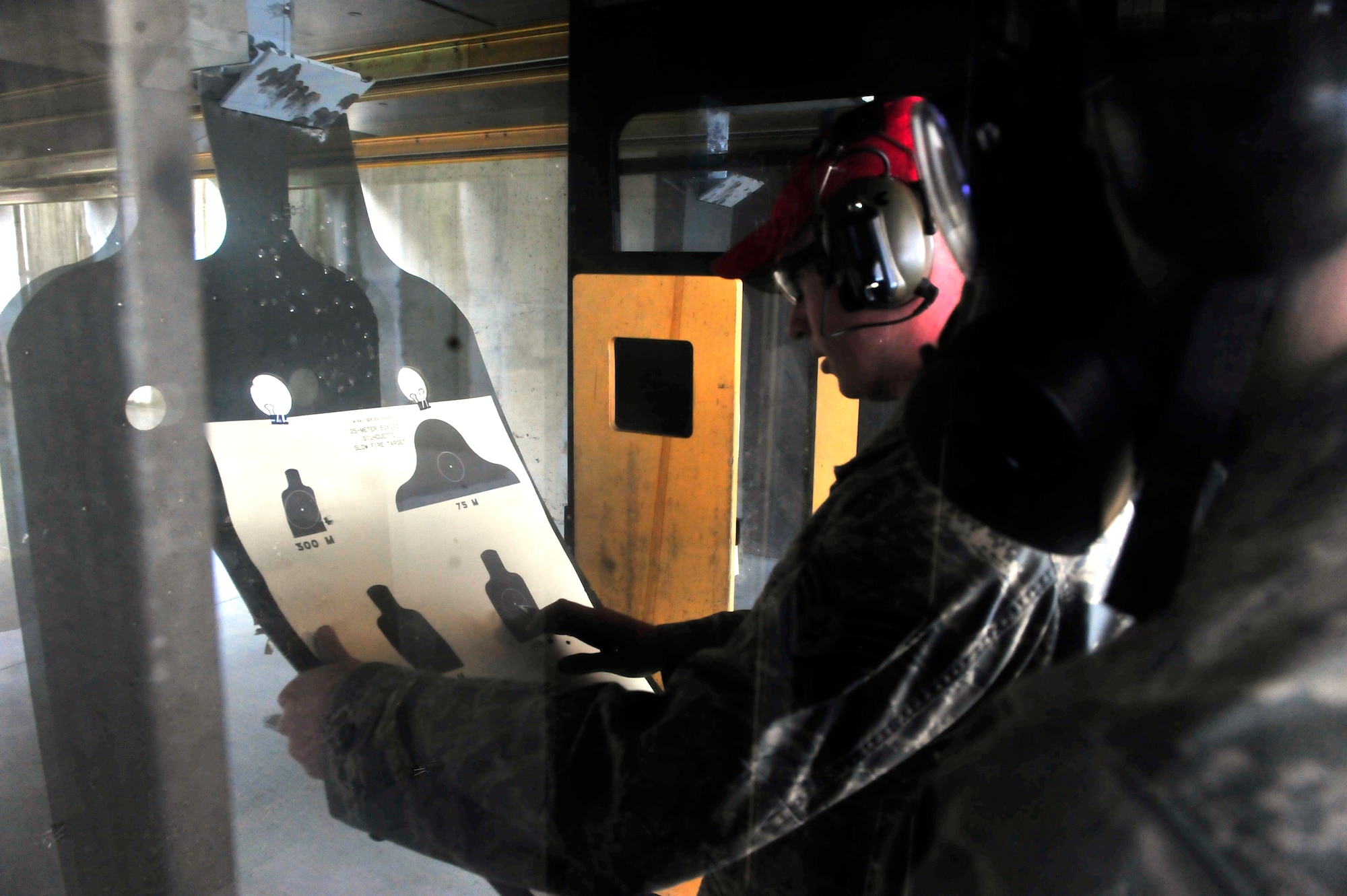 U.S. Air Force Staff Sgt. Alexander Nastas, 20th Security Forces Squadron combat arms maintenance and training instructor, grades an Airman’s scored hits on his target at Shaw Air Force Base, S.C. Feb. 27, 2012. Each qualification is broken down into portions by shooting styles, firing with gas masks and select target engagements. (U.S. Air Force photo by Senior Airman Neil D. Warner/Released)