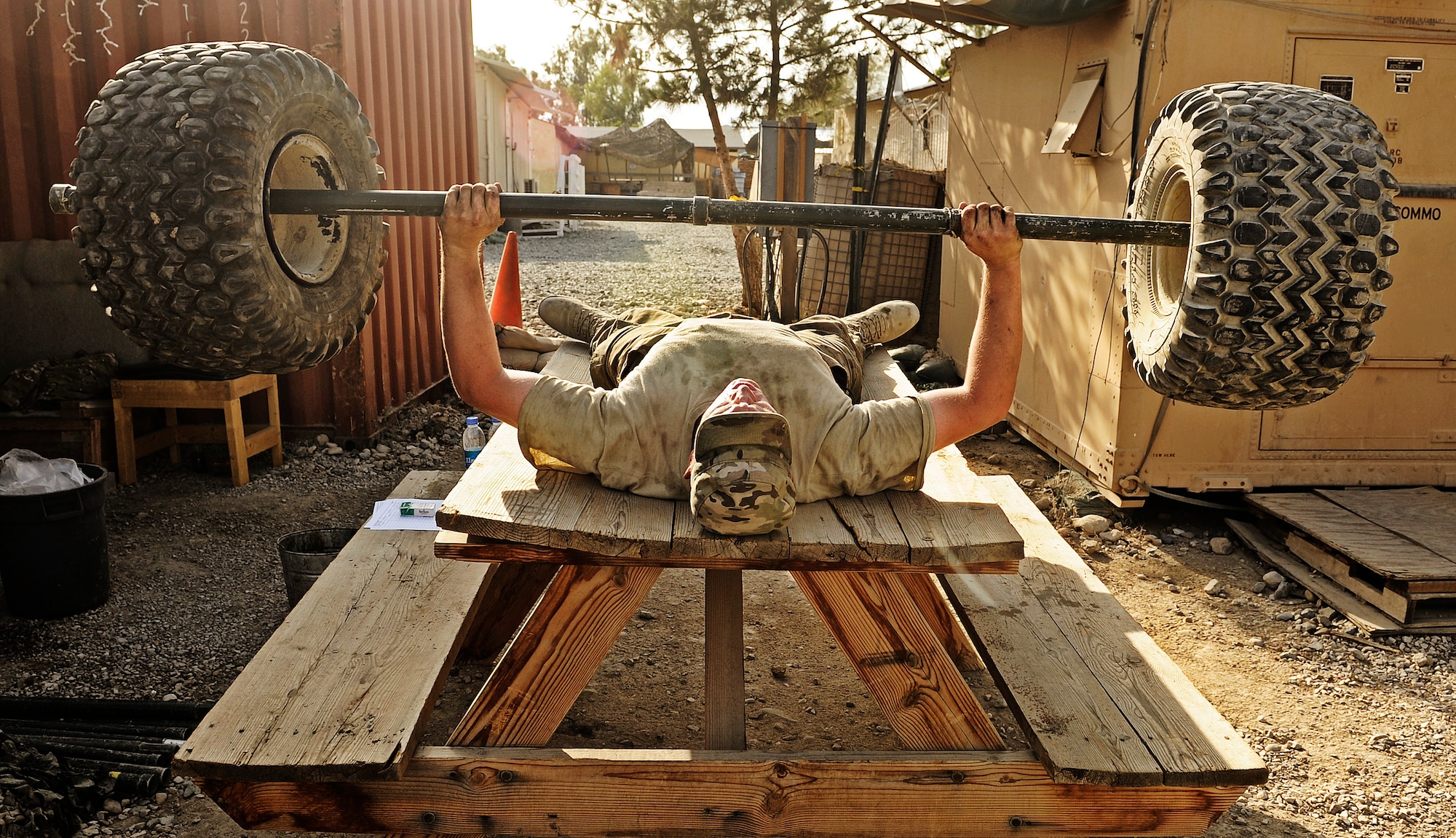Air Force Staff Sgt. Tim Husketh, vehicle maintainer attached to Laghman Provincial Reconstruction Team, finds time in his workday to pump some iron with a set of truck tires and a tent pole, July 30 at Forward Operating Base Mehtar Lam, Laghman Province, Afghanistan. Although the FOB has a perfectly useful gym with plenty of weights, sergeant Husketh enjoys his unique workout to a boring gym.