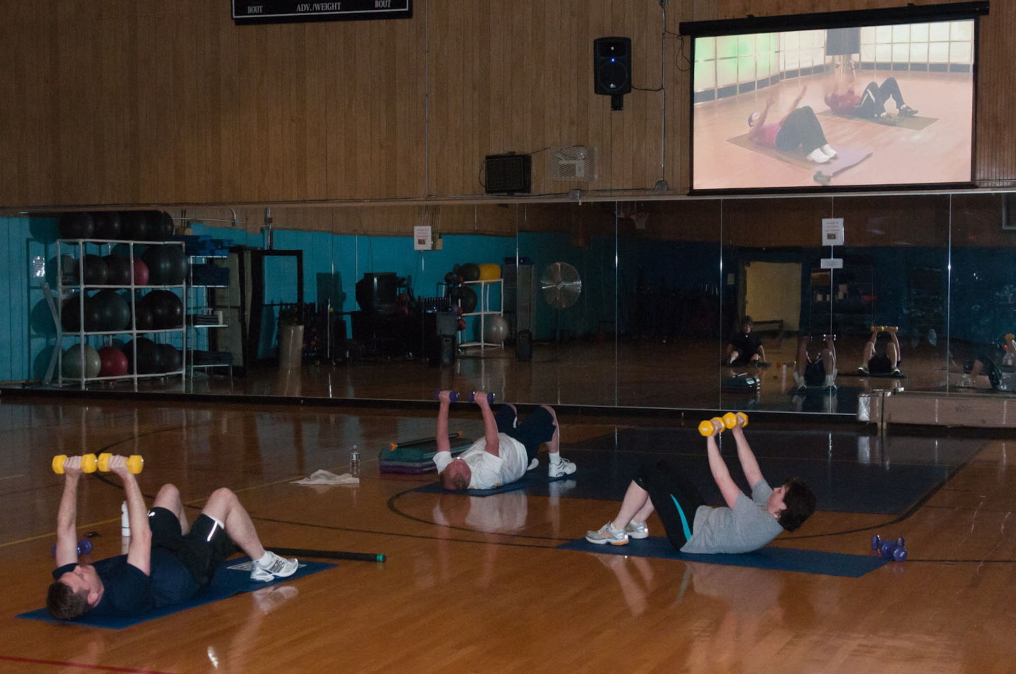HANSCOM AIR FORCE BASE, Mass. – Customers of the newly installed “Fitness on Request” kiosk work out in the Fitness and Sports Center March 7. This is just one of the many exercises included for group and individual sessions. (U.S. Air Force photo by Rick Berry)