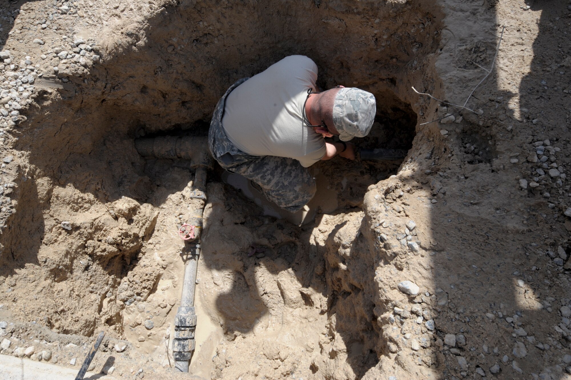 Staff Sgt. Antonio Martinez, 332nd Expeditionary Civil Engineer Squadron utilities shop member, cleans off a polyvinyl chloride pipe at an undisclosed location in Southwest Asia, March 7, 2012. The pipe is cleaned to ensure it will fit into a replacement piece. Martinez is deployed from Peterson Air Force Base, Colo., and is a Florida native. (U.S. Air Force photo by Staff Sgt. Joshua J. Garcia/Released)