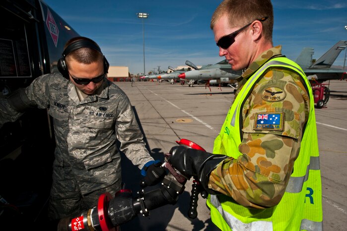 U.S. Air Force Airman Jaymes Dewitte, 99th Logistics Readiness Squadron fuels distribution apprentice, assists Royal Australian Air Force Leading Aircraftman Cameron Lawry, No. 75 Squadron crew chief, with a fuel hose during Red Flag 12-3 March 5, 2012 at Nellis Air Force Base, Nev. Red Flag is a realistic air-to-air combat training exercise involving the air forces of the United States and its allies. (U.S. Air Force photo by Senior Airman Brett Clashman)