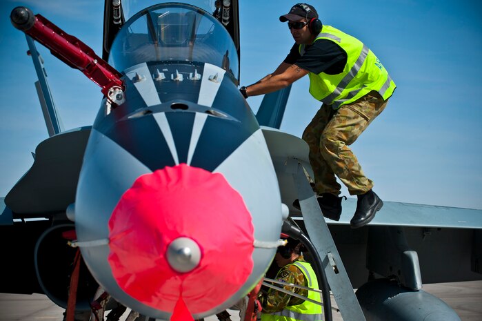 Royal Australian Air Force Sgt. Adam Ironmonger, No. 75 Squadron crew chief, climbs into an F/A-18 Hornet for pre-flight checks during Red Flag 12-3 March 5, 2012 at Nellis Air Force Base, Nev. Red Flag is a realistic air-to-air combat training exercise involving the air forces of the United States and its allies. (U.S. Air Force photo by Senior Airman Brett Clashman)
