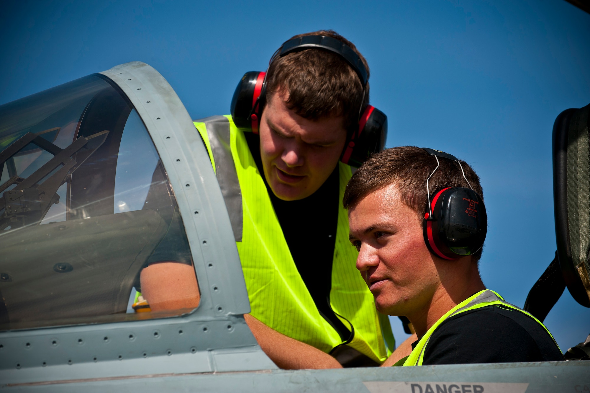 Royal Australian Air Force Leading Aircraftman Daniel Skinner (left) and LAC Adam Buying, No. 75 Squadron weapons specialists, perform pre-flight checks in an F/A-18 Hornet before a training mission during Red Flag 12-3, March 5, 2012 at Nellis Air Force Base, Nev. Red Flag is a realistic air-to-air combat training exercise involving the air forces of the United States and its allies. (U.S. Air Force photo by Senior Airman Brett Clashman)