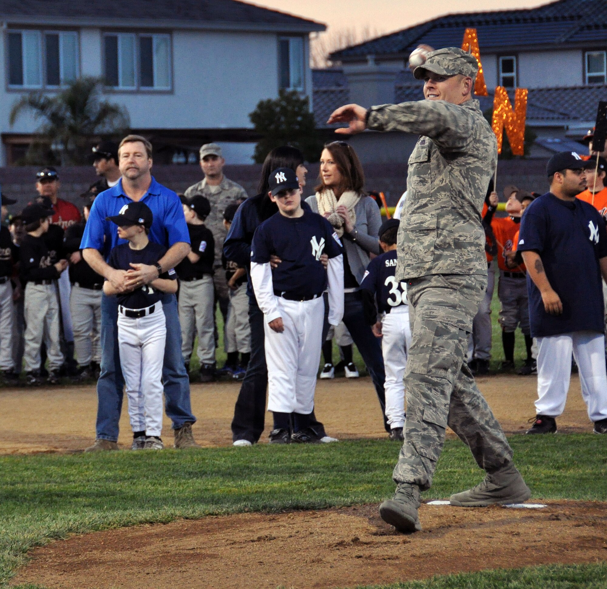 Staff Sgt. David Adkins, 60th Civil Engineer Squadron munitions NCO in charge, winds up the pitch to commemorate the opening of the season for the Vacaville National Little League March 2 in Arlington Park. Adkins was selected to open the season because of his actions in combat. (U.S. Air Force photo/Airman 1st Class Madelyn Ottem)
