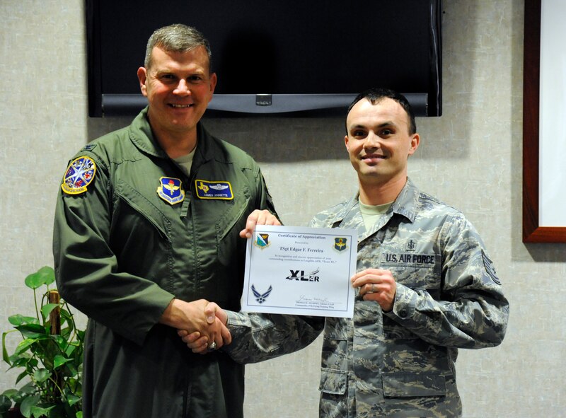 LAUGHLIN AIR FORCE BASE, Texas – Tech. Sgt. Edgar Ferreira, 47th Medical Support Squadron NCO in charge of laboratory services, poses with Col. James Jinnette, 47th Flying Training Wing vice commander, after being presented the XLer of the week award here Feb. 29. The XLer is a weekly award chosen by wing leadership and given to those who consistently make outstanding contributions to Laughlin and their unit. (U.S. Air Force photo/Airman 1st Class Nathan L. Maysonet)