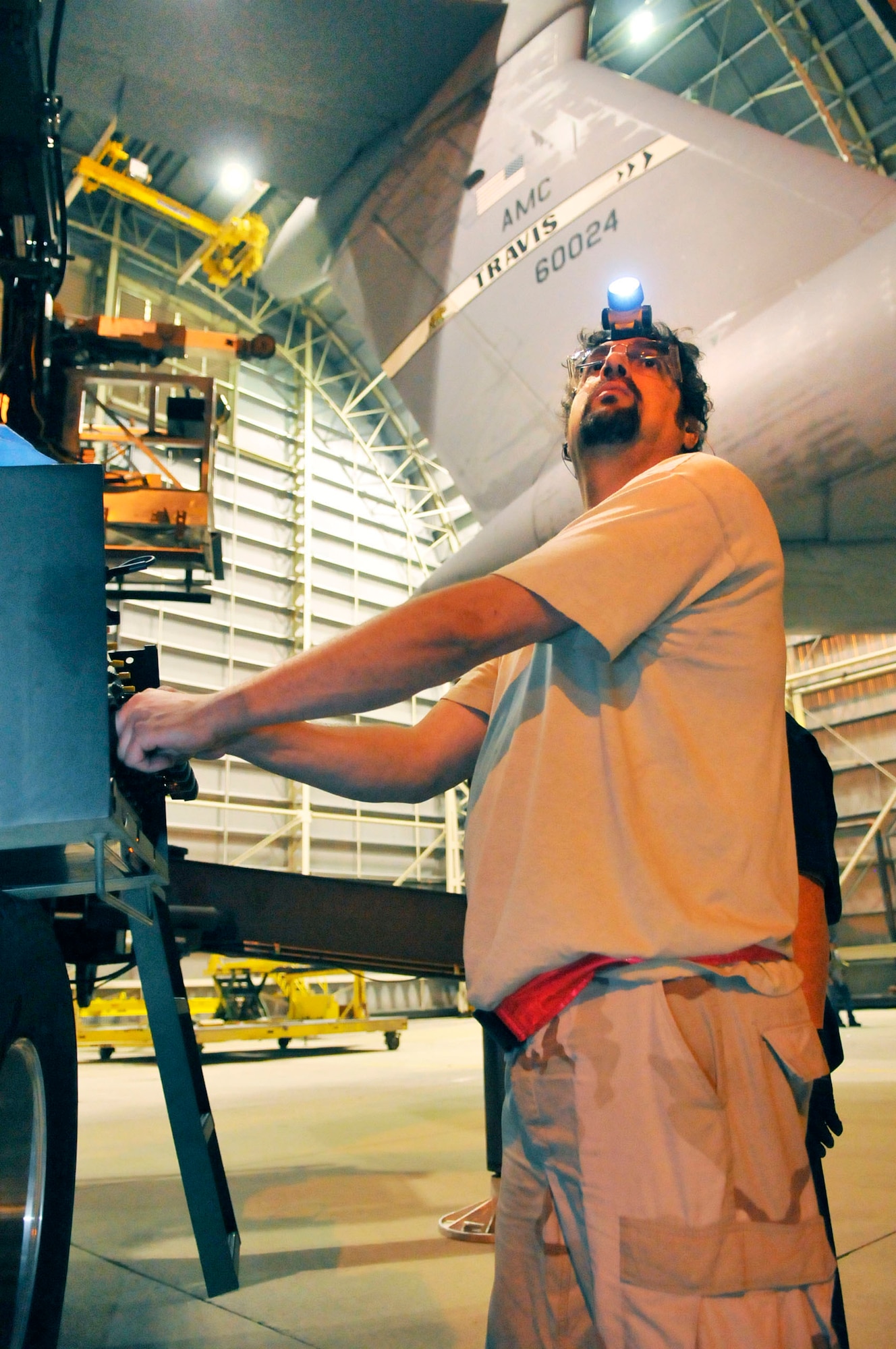 John Ference, flight control mechanic, works a lift as a C-5  from Travis AFB here for a horizontal stabilizer replacement, is prepared to be towed out of the hanger. (U. S. Air Force photo by Sue Sapp)