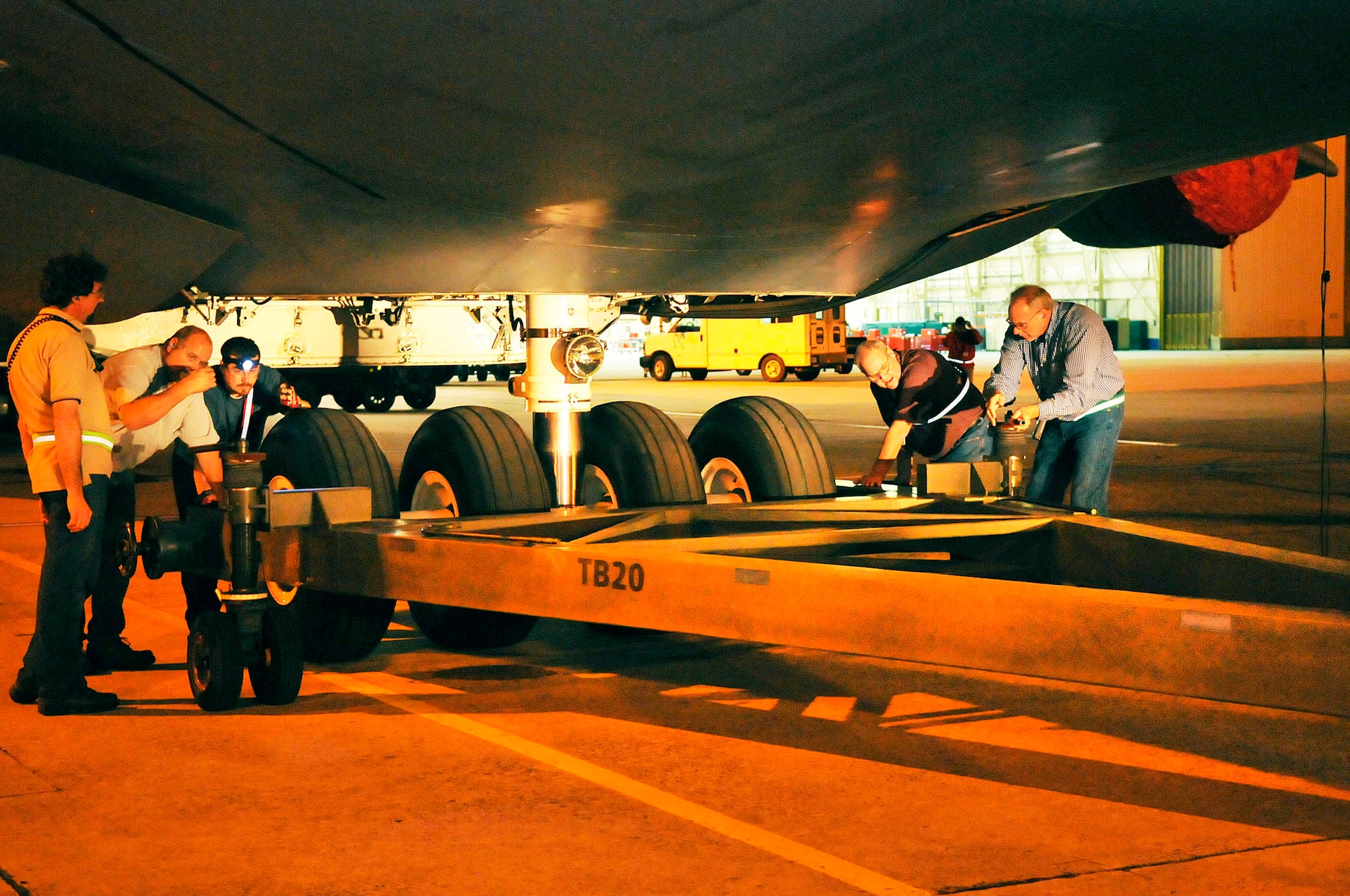 Swing shift tow crew members connect the tow bar to the front wheels of the C-5 before it is moved from the hangar to the flightline. (U. S. Air Force photo by Sue Sapp)