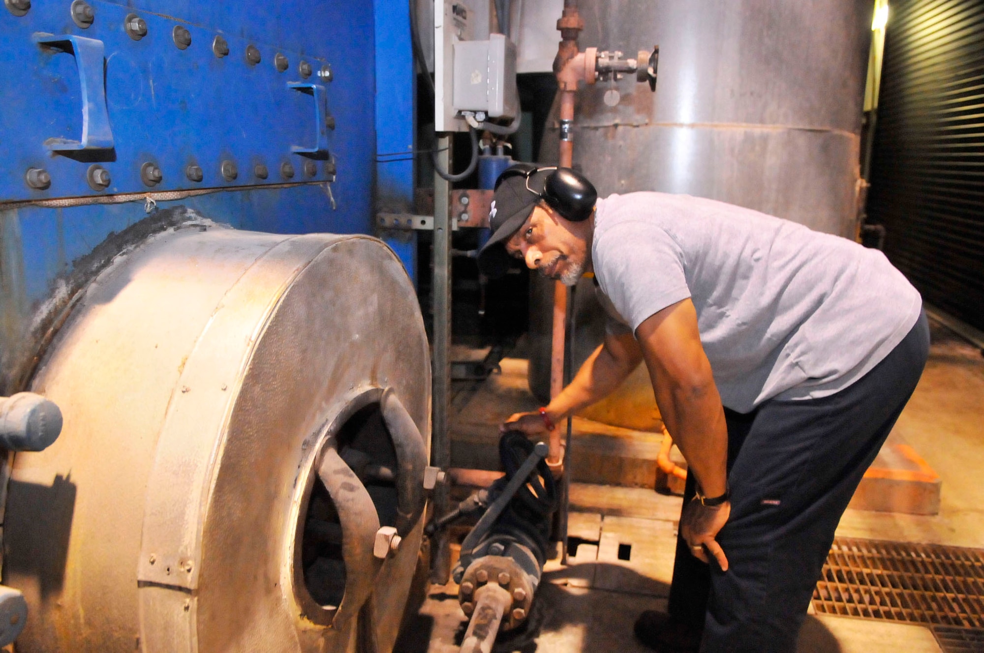 Sid Brown, boiler plant operator, works with a boiler to remove sediment from the water. (U. S. Air Force photo by Sue Sapp)