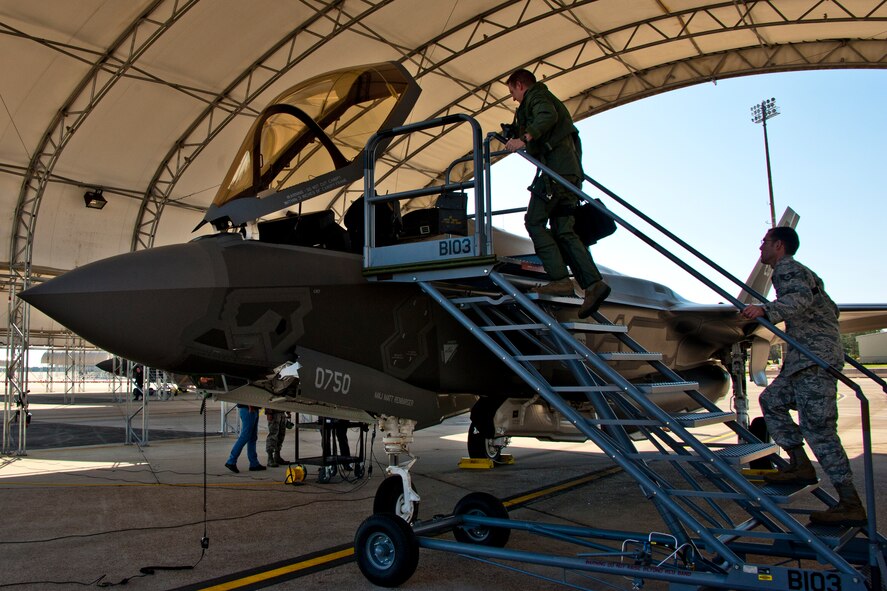 Lt. Col. Eric Smith, the 58th Fighter Squadron director of operations, walks up to the cockpit of the F-35A Lightning II joint strike fighter, followed by Staff Sgt. Jeremy Houser, aircraft crew chief for the sortie, prior to its first-ever training sortie March 6 at Eglin Air Force Base, Fla.  Smith is the first Air Force pilot qualified to fly the F-35.  (U.S. Air Force photo/Samuel King Jr.)