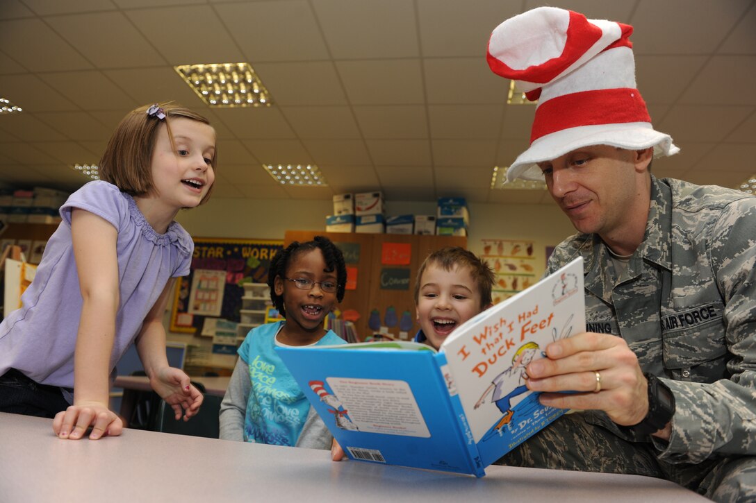 RAF CROUGHTON, United Kingdom - Master Sgt. Gabriel Browning reads a Dr. Seuss book to children at RAF Croughton Elementary School March 2. Volunteers, to include the Cat in the Hat, read books by Dr. Seuss and other authors to kindergarten and first graders to celebrate Dr. Seuss’ birthday. Browning is a member of the 422nd Communications Squadron. (U.S. Air Force photo by Tech. Sgt. Barton)