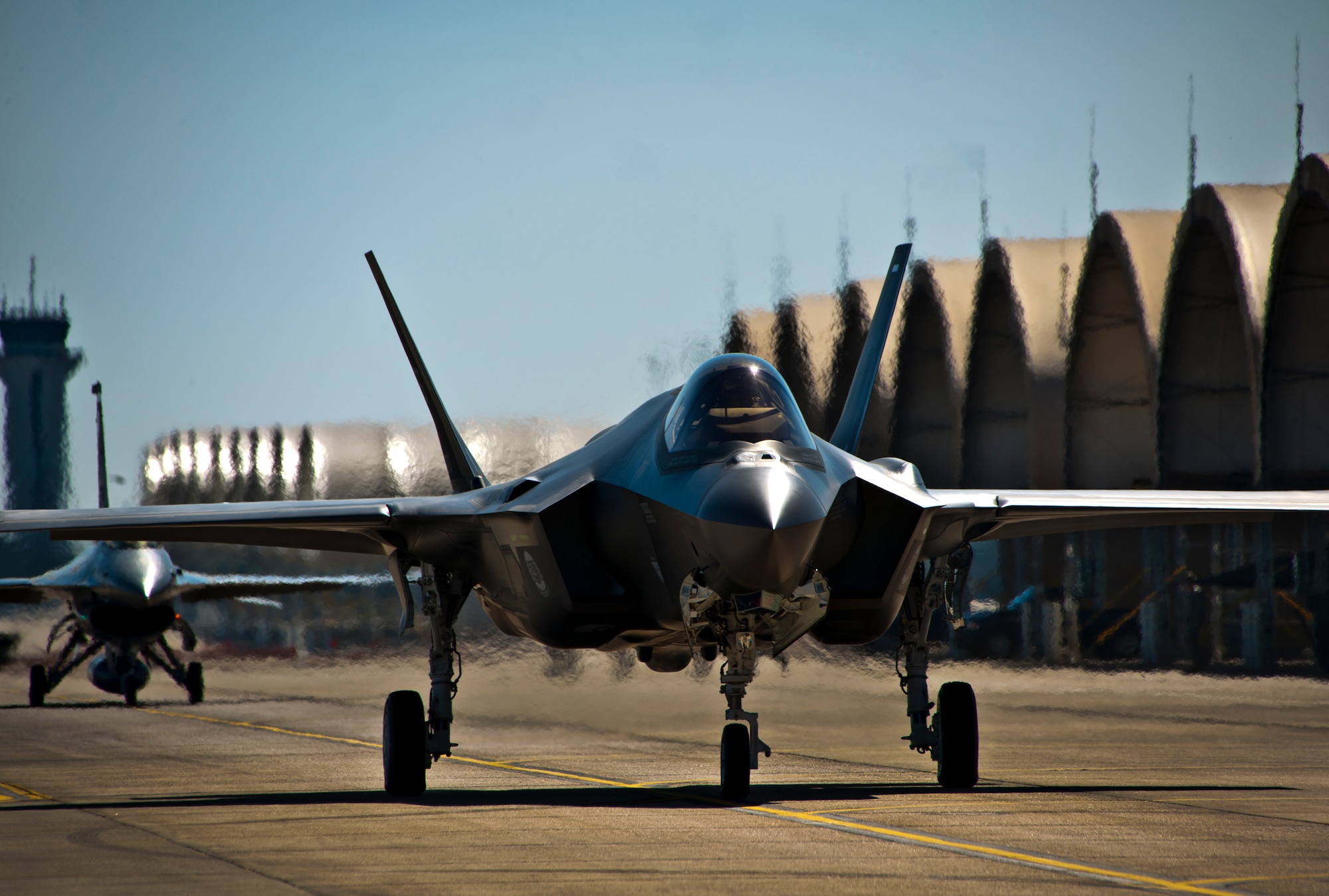The F-35A Lightning II joint strike fighter taxis out for its first training sortie followed by an F-16 chase aircraft March 6 at Eglin Air Force Base, Fla. (U.S. Air Force photo/Samuel King Jr.)