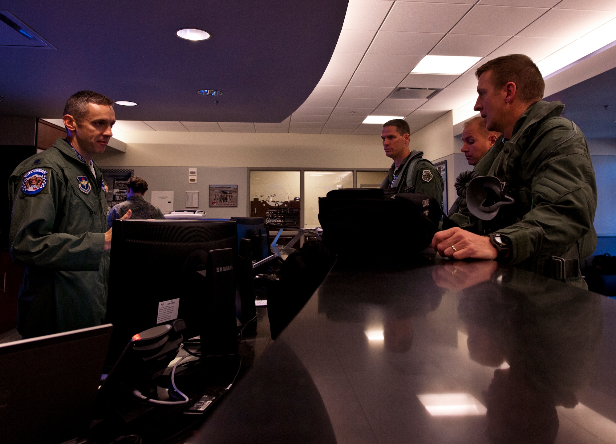 (Right to left) Lt. Col. Eric Smith, the first Air Force qualified F-35 pilot, Maj. Joseph Bachmann, the first Marine qualified F-35 pilot, and Lt. Col. Lee Kloos, the 58th Fighter Squadron commander, receive an operations brief from Lt. Col. Todd LaFortune before stepping out for the first-ever F-35A Lightning II joint strike fighter training sortie March 6 at Eglin Air Force Base, Fla.  (U.S. Air Force photo/Samuel King Jr.)