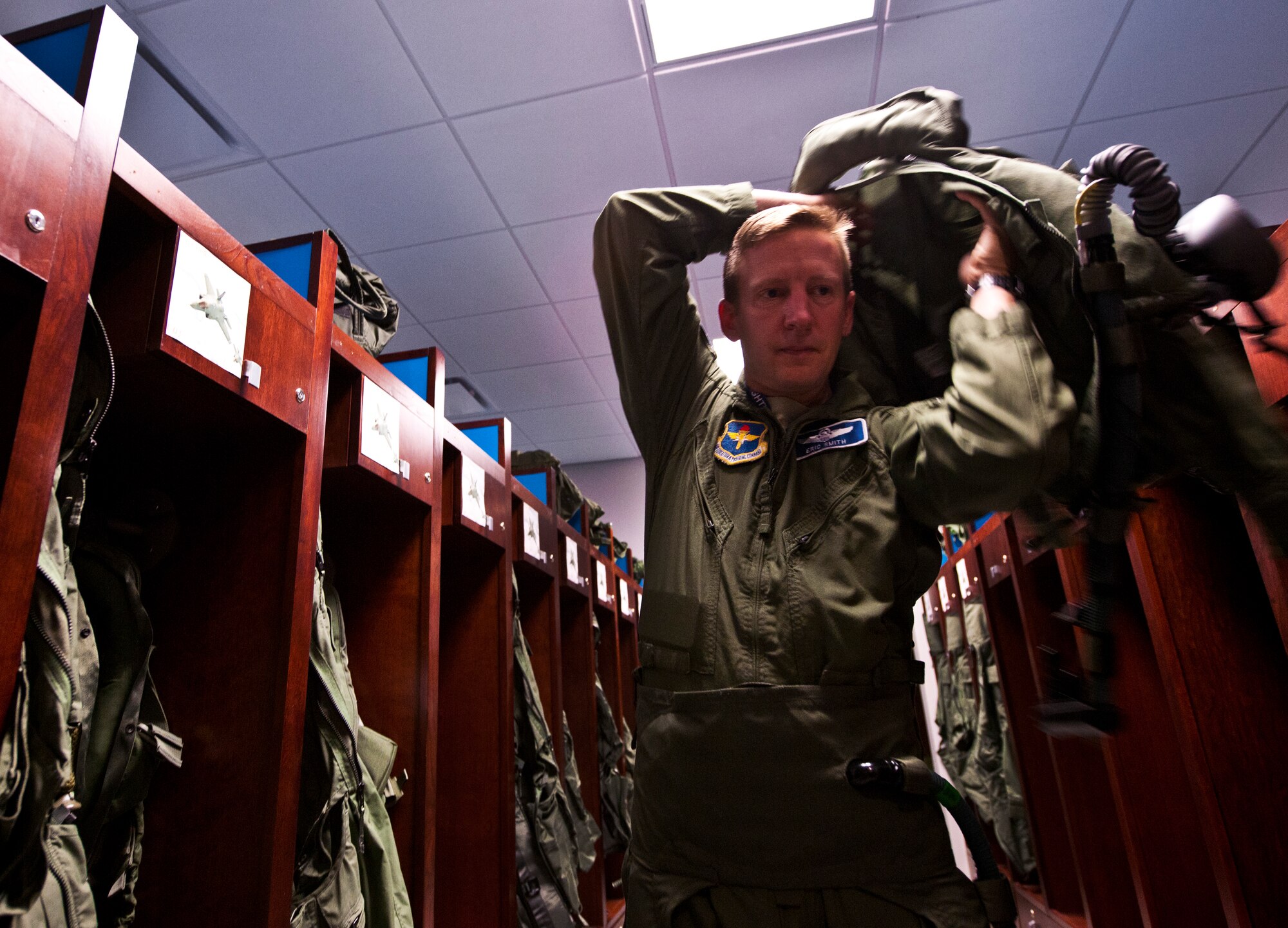 Lt. Col. Eric Smith, the 58th Fighter Squadron director of operations, puts on his flight gear prior to stepping to the F-35A Lightning II joint strike fighter for its first-ever training sortie March 6 at Eglin Air Force Base, Fla.  Smith is the first Air Force pilot qualified to fly the F-35.  (U.S. Air Force photo/Samuel King Jr.)