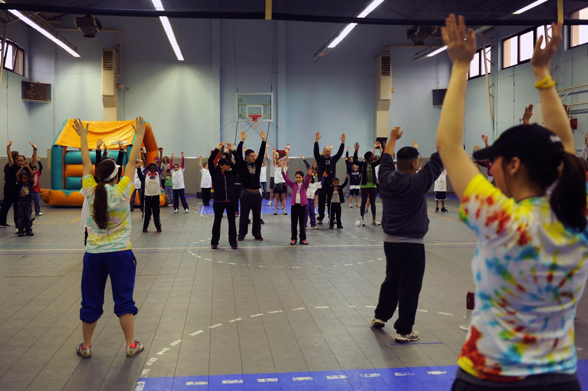 SPANGDAHLEM AIR BASE, Germany – Volunteers direct Department of Defense Dependents Schools’ students and their parents through stretches during the FitFactor X-Games event at the Spangdahlem Middle School here March 3. The 52nd Force Support Squadron Youth Programs sponsored the event to introduce and familiarize students and their parents with fitness and health initiatives. FitFactor is an Air Force-wide youth fitness and health program that challenges children age 6 to 18 to be active for an hour each day, eat right and make healthy lifestyle choices. (U.S. Air Force photo by Airman 1st Class Matthew B. Fredericks/Released)