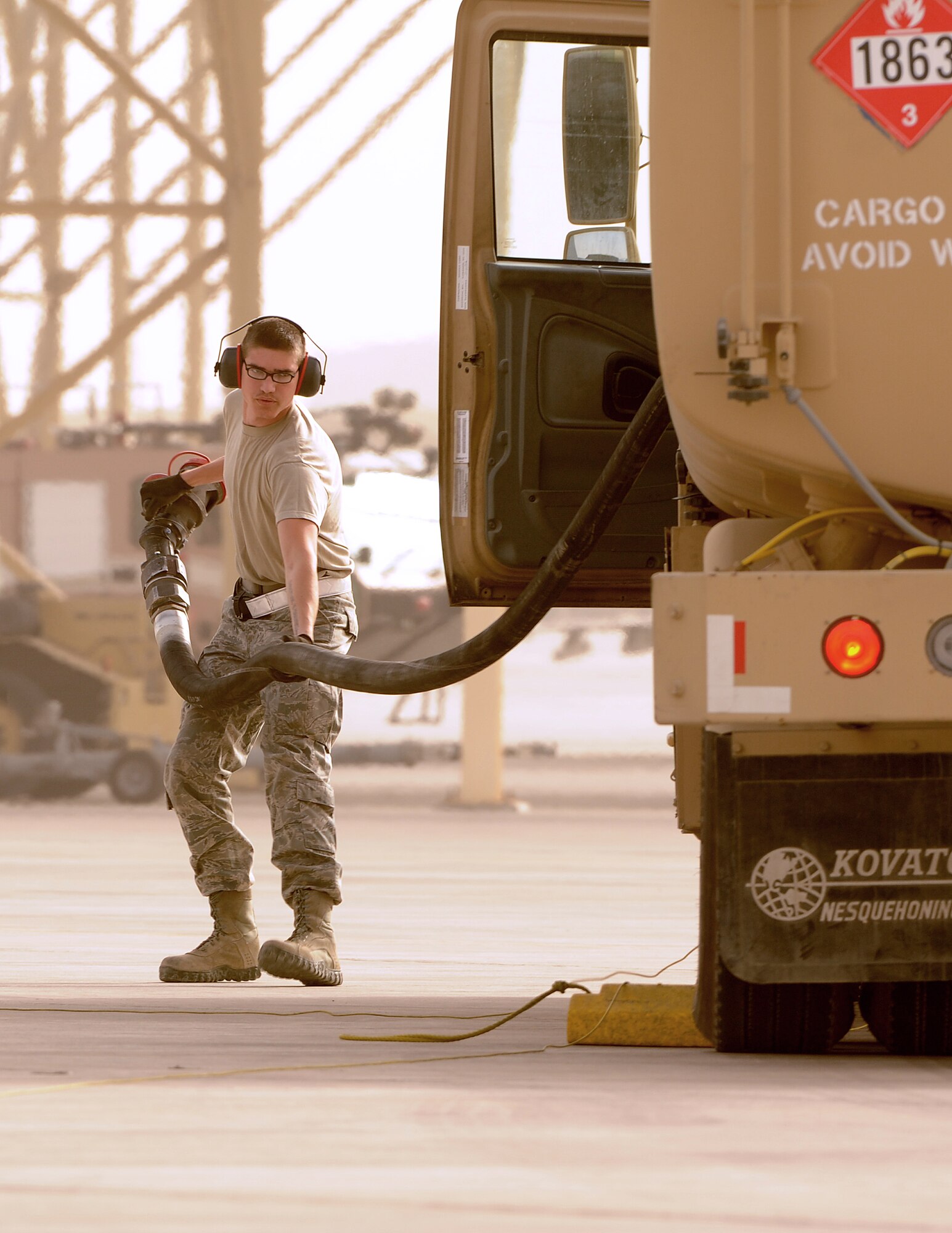 SOUTHWEST ASIA - Airman 1st Class Michael Johnson drags a refueling pump to an F-15 Eagle during hot pit refueling on the flightline March 2, 2012. Hot pit refueling is conducted to fuel aircraft while they are still running to reduce ground time and get aircraft back up in the air as soon as possible. Johnson is assigned to the 380th Expeditionary Logistics Readiness Squadron and is assigned to Joint Base Charleston, S.C.  (U.S. Air Force photo/Tech. Sgt. Arian Nead)


